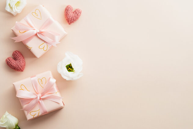Valentines Day flat lay composition. Valentines gifts and rose buds on beige background. Minimalist style.
