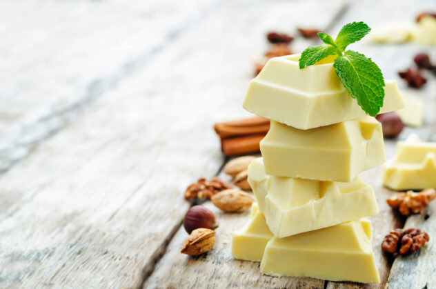 white chocolate on a white wood background. the toning. selective focus