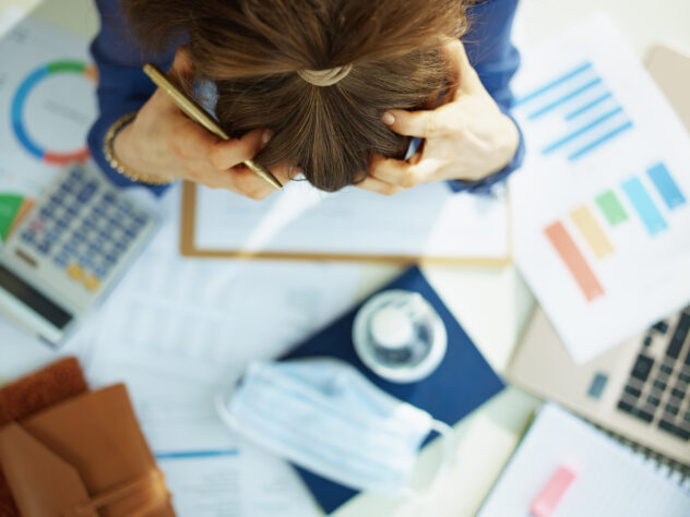 Upper view of stressed middle age business woman at the table.