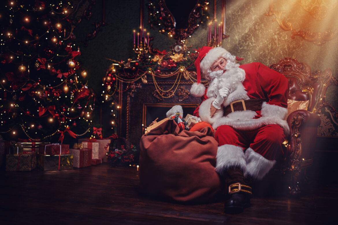 Santa Claus brought gifts for Christmas and having a rest by the fireplace. Christmas and New Year concept. Home decoration.