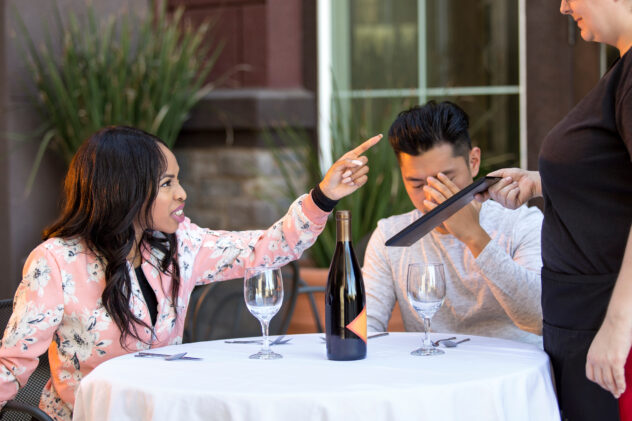 Couple on a date angry at a waitress in an outdoor restaurant.  They are upset and dissatisfied with the customer service or the food in the cafe.  The image depicts the food and service industry.