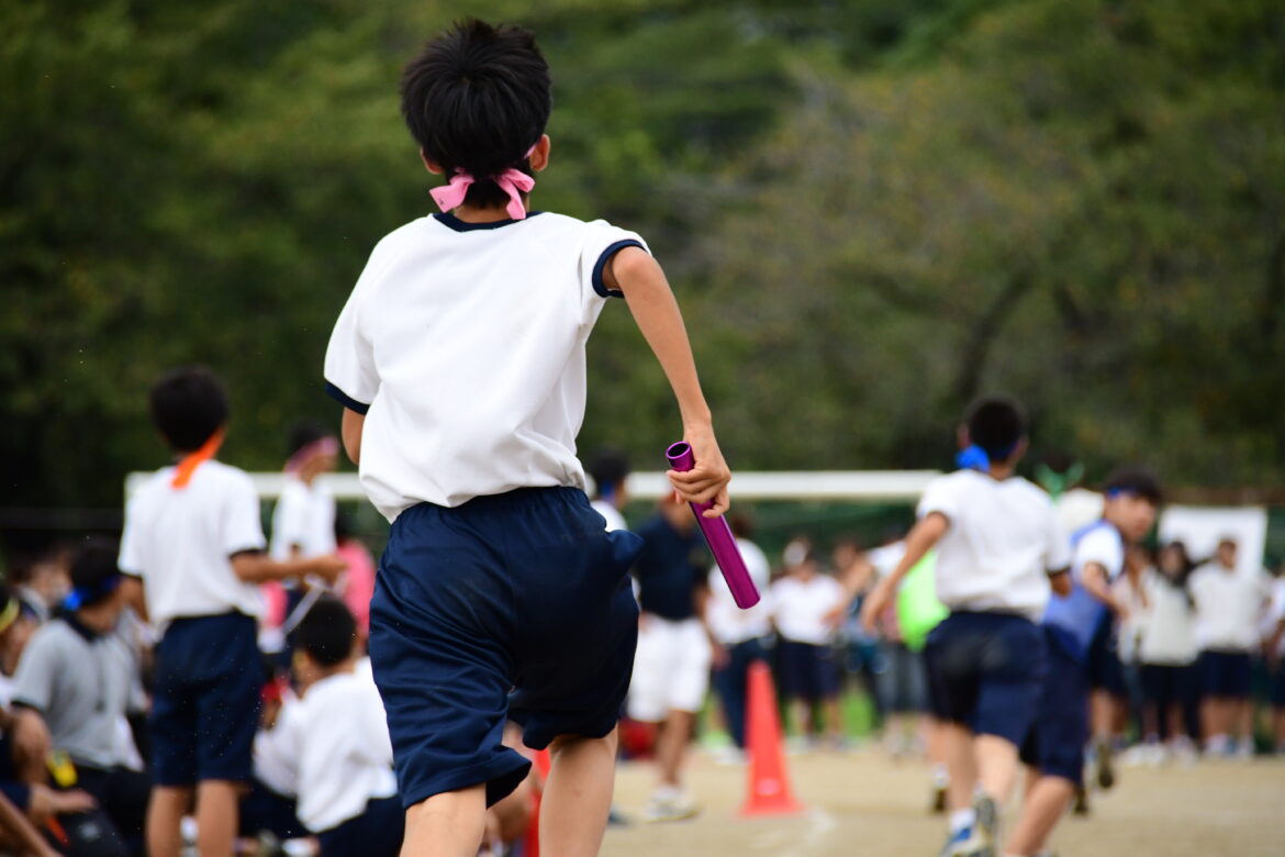 Students running in a field. Sports day in Japan.