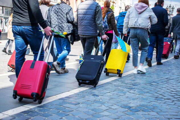 Ukrainian refugees leave Ukraine. Stations of Western Ukraine are filled with migrants. Ukrainian symbols on suitcases. humanitarian crisis. Action in support of refugees. Focus on suitcases