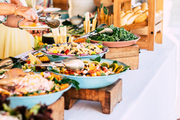 close up of view of table full of food with someone taking pasta of the table to celebrate - caucasian woman